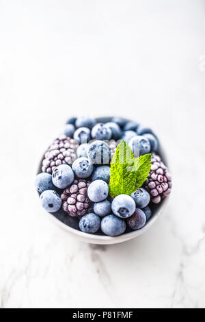 Close-up de bleuets surgelés et les mûres avec des feuilles de menthe. Banque D'Images
