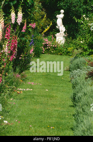 Dans l'herbe à côté des frontières digitales conduisant à la statue classique en français pays jardin en été Banque D'Images