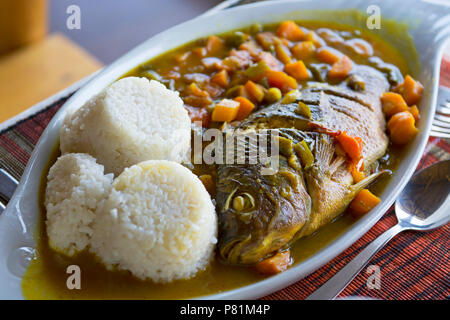 Ragoût de poisson, le tilapia (Ngege ougandais), avec des Carottes Tomates Oignons Poivrons verts, servis avec du riz, en Ouganda, en Afrique de l'alimentation Banque D'Images