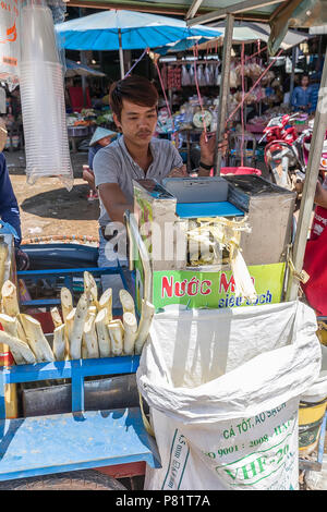 Vendeur de rue, presser la canne à sucre pour faire des boissons sucrées en marché, Pakse, Laos Banque D'Images