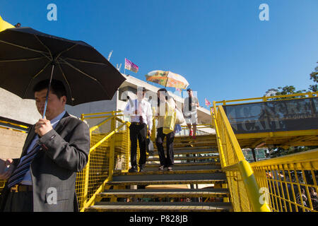 Les touristes japonais sur la rive sud de Londres se protéger du soleil avec des parasols Banque D'Images