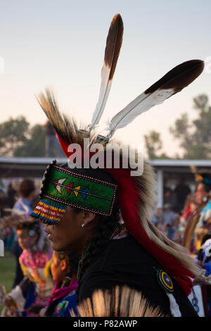 Les jeunes hommes autochtones américaines danseur pow wow avec un serre-tête en perles et ornements de costumes. Cheveux noirs est tressé et ses yeux sont protégés par des perles. Banque D'Images