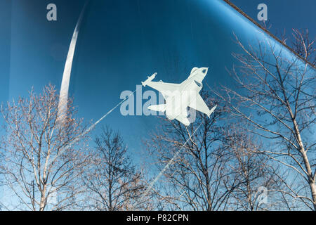 ARLINGTON, Virginie, États-Unis — gravure rétroéclairée d'un avion de chasse F-16 dans un panneau de verre au US Air Force Memorial à Arlington, Virginie, avec les flèches imposantes du mémorial visibles en arrière-plan. Cette œuvre d'art honore l'héritage de l'US Air Force, combinant des éléments de design modernes avec des représentations symboliques du vol et du service militaire. Banque D'Images