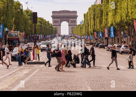 Paris, France - 23 juin 2018 : une foule de personnes traversant l'Avenue des Champs-Elysées avec l'Arc de Triomphe en arrière-plan Banque D'Images