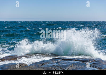 Éclaboussures des vagues contre les rives rocheuses de Jomfruland, la Norvège. Banque D'Images