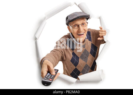 Un homme âgé avec une télécommande Breaking through paper Banque D'Images