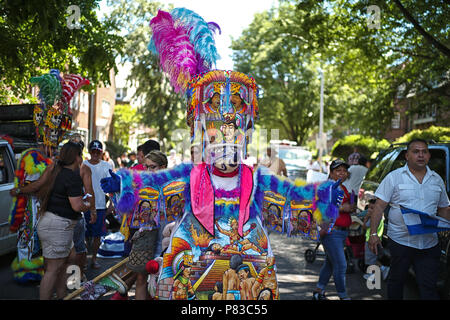 New York City, Queens, États-Unis. 8 juillet, 2018. Chinelos sont une sorte de danseuse en costume traditionnel qui est populaire dans l'état Mexicain de Morelos, parties de l'État de Mexico et le District fédéral de Mexico, en particulier les quartiers de Milpa Alta et Xochimilco. La tradition est issue d'un mélange de peuples et de traditions catholiques, notamment le carnaval, avec sa permission d'être masqué et à des simulacres. Chinelos mock Européens et Européennes les manières de la période coloniale jusqu'à la fin du xixe siècle. Célébration de la fête des fleurs à New York, le long de la 37e Avenue, Banque D'Images