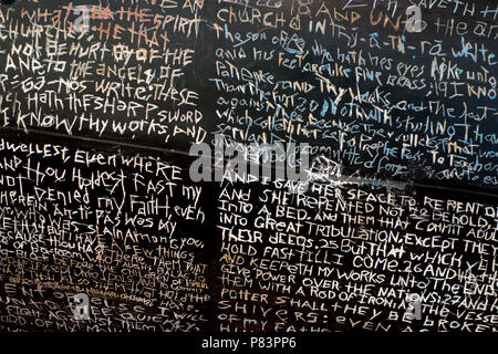 Écriture religieuse au hasard dans un mur rayé noir à Toronto, Ontario, Canada restaurant Banque D'Images