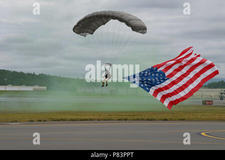 Un cavalier de sauveteurs-parachutistes de l'Alaska Air National Guard, 212e Escadron de sauvetage, des terres avec le drapeau américain le 30 juin 2018, at Joint Base Elmendorf-Richardson, en Alaska. Pour ouvrir l'Arctique 2018 Thunder Open House, membres de sauveteurs-parachutistes ont sauté d'un C-130 Hercules pendant l'hymne national, l'exécution et de l'Alaska américain drapeaux. (U.S. Air Force photo par un membre de la 1re classe Haley Stevens) Banque D'Images