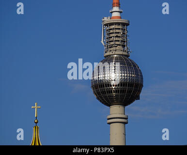 La lumière du soleil fait croix sur Berlin Tour de Communication connu sous le nom de "vengeance du Pape." La croix de la cathédrale catholique à proximité est en premier plan. Banque D'Images