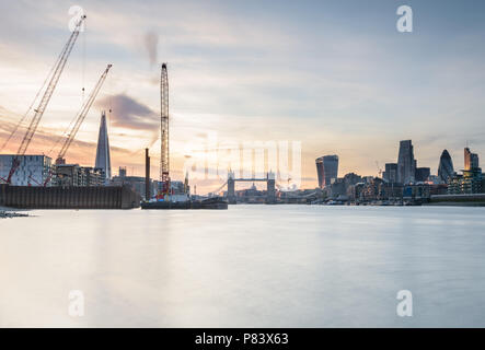 Coucher de soleil derrière le tesson et le Tower Bridge à Londres tourné de Bermondsey par la Tamise à l'aide d'une longue exposition Banque D'Images