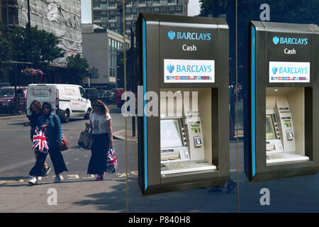 Les gens reflétée dans la fenêtre transport, Union Jack flag sacs, passer devant la banque Barclays ATM dans Notting Hill, Londres. Banque D'Images