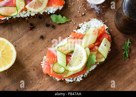 Sandwich au saumon, concombre et fromage à la crème sur fond de bois, vue du dessus. Sandwich au saumon sain ou toast Banque D'Images