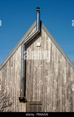 Pignon en bois et la cheminée en métal d'un chalet en Auvergne, France Banque D'Images