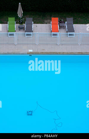 Robot de nettoyage dans une piscine et de chaises longues sur le bord, Soth de France Banque D'Images