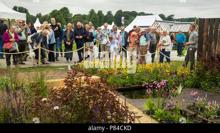 Personnes voir fleurs colorées et dispositif de l'eau dans le magnifique spectacle primé jardin, plein air - Chatsworth RHS Flower Show, England, UK. Banque D'Images