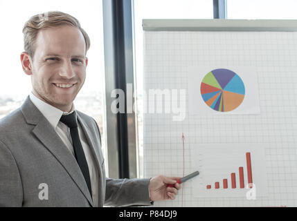 L'homme d'affaires faisant la présentation de rapports dans les diagrammes et graphiques au tableau à feuilles mobiles dans offfice Banque D'Images