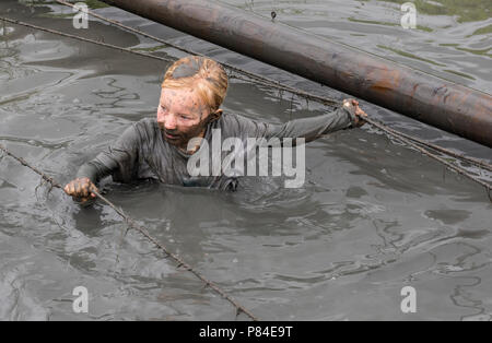 Biddinghuizen, Pays-Bas - le 23 juin 2018 : l'enfant durant un mud run (mudraise, charité) dans la boue et dans l'eau noire. Banque D'Images