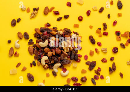 Mélange de fruits séchés et les noix sur fond jaune Banque D'Images