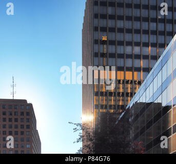 Syracuse, New York, USA. 1 juillet 2018. Tour Axa l et balise météo reflétée sur la façade de la tour ll au lever du soleil au centre-ville de Syracuse, New York. Banque D'Images