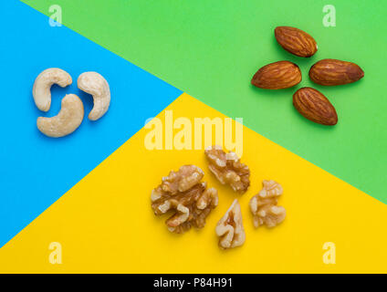 Close up image d'écrous. Les amandes et les noix de cajou, sur bleu, vert et jaune d'artifices Banque D'Images