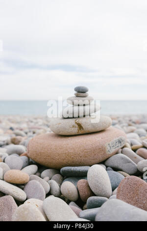 Tas de petites pierres se trouvant sur l'autre en forme d'arbre de Noël sur la mer. Banque D'Images