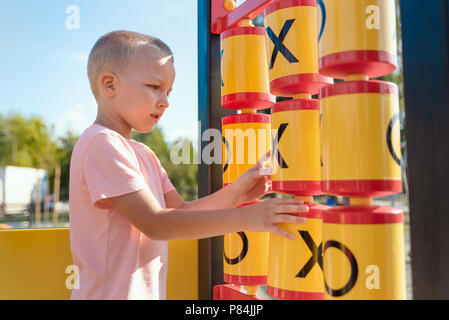 Boy est jouer Tic Tac Toe jeu dans l'aire de jeux. Loisirs Piscine en plein air concept Banque D'Images