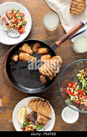 Une viande dans le moule sur une table en bois avec des légumes frais Salade de pois chiches et de quinoa noir, de grillé et de limonade, vue d'en haut. Maison simple et saine Banque D'Images