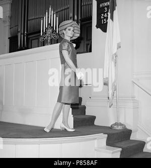 Un modèle établit un poser lors d'un shoot de mode dans une église en Californie, ca. 1965. Banque D'Images