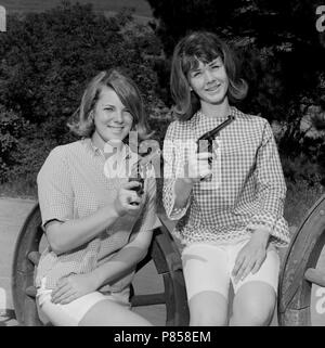 Deux jeunes femmes occupent des revolvers pour rodeo photographie publicité en Californie, ca. 1964 Banque D'Images