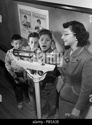 Enseignant travaille avec les élèves de la classe de la santé sur la gestion du poids, ca. 1955. Banque D'Images