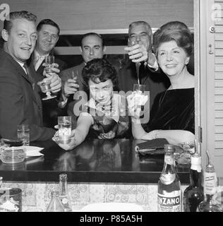 Les banlieusards californiens prendre un verre au bar patio d'une maison, ca. 1959. Banque D'Images