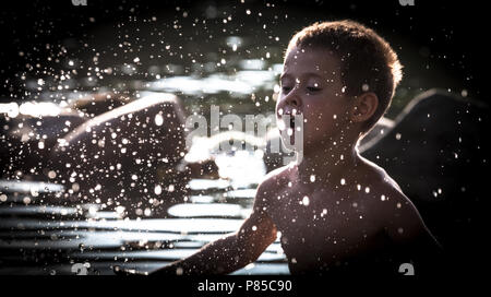 Un garçon joue dans l'eau. Banque D'Images