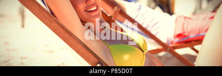 Portrait de jeune femme relaxaing on lounge chair at beach Banque D'Images