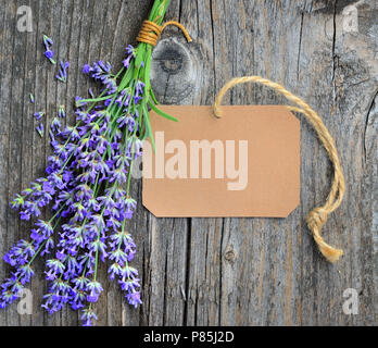 Fleurs de lavande (Lavandula) avec tag papier sur une vieille table en bois Banque D'Images