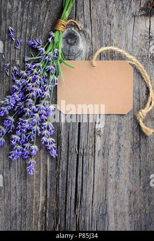 Fleurs de lavande (Lavandula) avec tag papier sur une vieille table en bois Banque D'Images