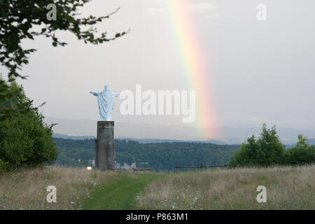 Christus kerk op top van het landschap heuvel rencontré sur rencontré regenboog. Statue du Christ en haut d'une colline avec vue sur paysage avec arc-en-ciel. Banque D'Images