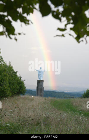 Christus kerk op top van het landschap heuvel rencontré sur rencontré regenboog. Statue du Christ en haut d'une colline avec vue sur paysage avec arc-en-ciel. Banque D'Images