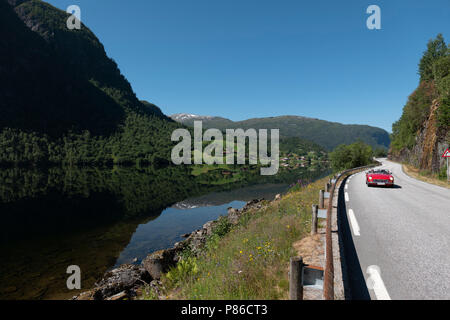 Conduire une voiture de sport rouge sur la belle route Gaularfjell, Norvège Banque D'Images