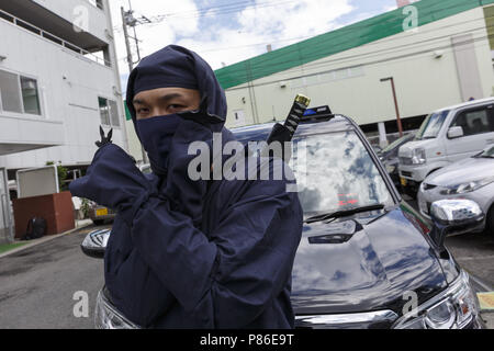 Yokohama, Japon. 09 juillet 2018. Un chauffeur de taxi habillés en costume de Ninja (ninja shuriken montre ses armes) à l'extérieur du groupe Sanwa Koutsu Compagnie de taxi à Yokohama. À base de fournisseur de Yokohama taxi Sanwa Koutsu Group a lancé un nouveau service appelé ''Taxi'' de Ninja pour attirer les clients locaux et étrangers. Les chauffeurs de taxi en costume Ninja offrent une expérience unique aux clients, montrant leurs capacités de ninja, comme étapes rapides et signes de doigts. Le service de taxi ninja a commencé à partir de la mi-juin et peuvent être réservés sur leur site web (disponible en anglais, chinois et japonais), avec un supplément (1 000 JPY ou Banque D'Images