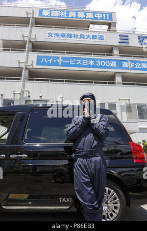 9 juillet 2018 - Yokohama, Japon - Un chauffeur de taxi habillés en costume de Ninja pose pour une photo à côté de sa cabine, à l'extérieur de la compagnie de taxi Groupe Sanwa Koutsu à Yokohama. À base de fournisseur de Yokohama taxi Sanwa Koutsu Group a lancé un nouveau service appelé ''Taxi'' de Ninja pour attirer les clients locaux et étrangers. Les chauffeurs de taxi en costume Ninja offrent une expérience unique aux clients, montrant leurs capacités de ninja, comme étapes rapides et signes de doigts. Le service de taxi ninja a commencé à partir de la mi-juin et peuvent être réservés sur leur site web (disponible en anglais, chinois et japonais), avec un supplément (1 000 JPY Banque D'Images