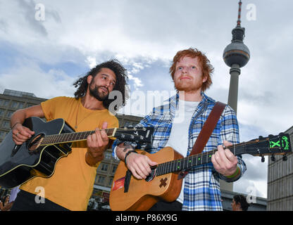 Berlin, Allemagne. 29 Juin, 2018. Une figure de cire par le chanteur britannique Ed Sheeran du musée de cire Madame Tussauds est affiché sur l'Alexanderplatz. Le musicien Nadia Alami (L) joue de la guitare et chanter à côté de lui. La figure s'affiche pendant trois mois chez Madame Tussauds à Berlin. Ed Sheeran est de donner un concert à Berlin la semaine prochaine. Credit : Jens Kalaene Zentralbild-/dpa/dpa/Alamy Live News Banque D'Images