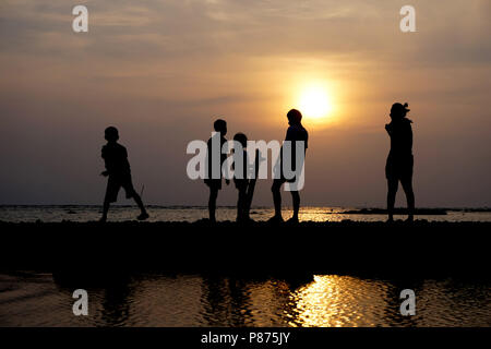 Groupe de personnes Silhouette au coucher du soleil sur la plage Banque D'Images