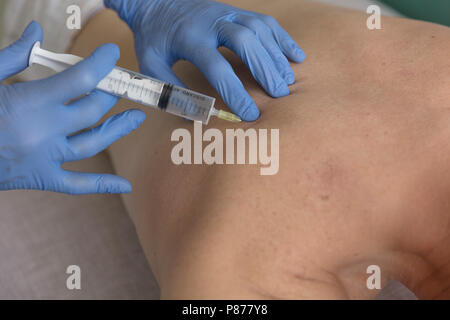 Portrait of handsome mature doctor dans les gants de faire une injection de l'homme Banque D'Images