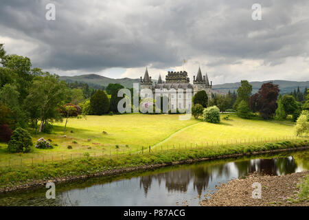 Château d'Inveraray reflétée dans la rivière Aray avec de sombres nuages et l'herbe d'or dans les Highlands écossais Scotland UK Banque D'Images