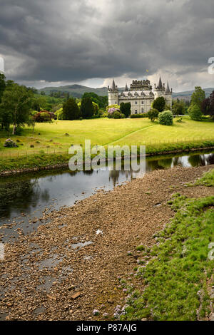 Inveraray Castle dans bien reflétée dans la rivière Aray à Loch Fyne avec de sombres nuages et soleil dans les Highlands écossais Scotland UK Banque D'Images