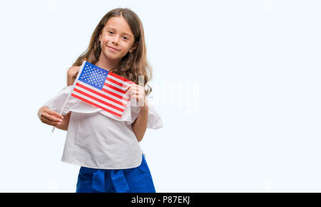 Brunette woman holding drapeau de États-Unis d'Amérique avec un visage heureux et souriant debout avec un sourire confiant montrant les dents Banque D'Images