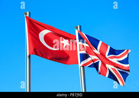 Le turc et l'UK Les drapeaux sur fond de ciel bleu Banque D'Images