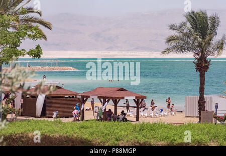 Baigneurs et touristes appréciant une plage à Ein Bokek sur la mer Morte en Israël avec des montagnes jordaniennes en arrière-plan Banque D'Images