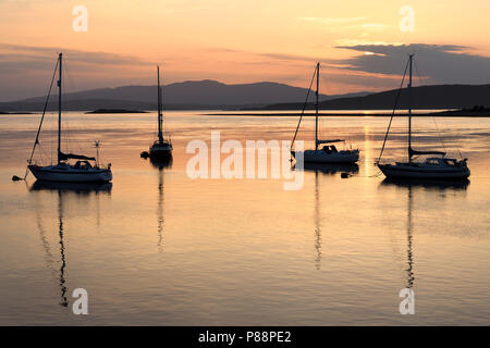 Ciel rouge le coucher du soleil sur la baie d'Ardmucknish à North Connel et aéroport Oban avec voiliers en silhouette Banque D'Images